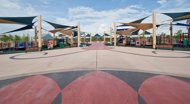 Fabric shade structures provide sun protection over amusement park queue lines, enhancing comfort for waiting visitors.