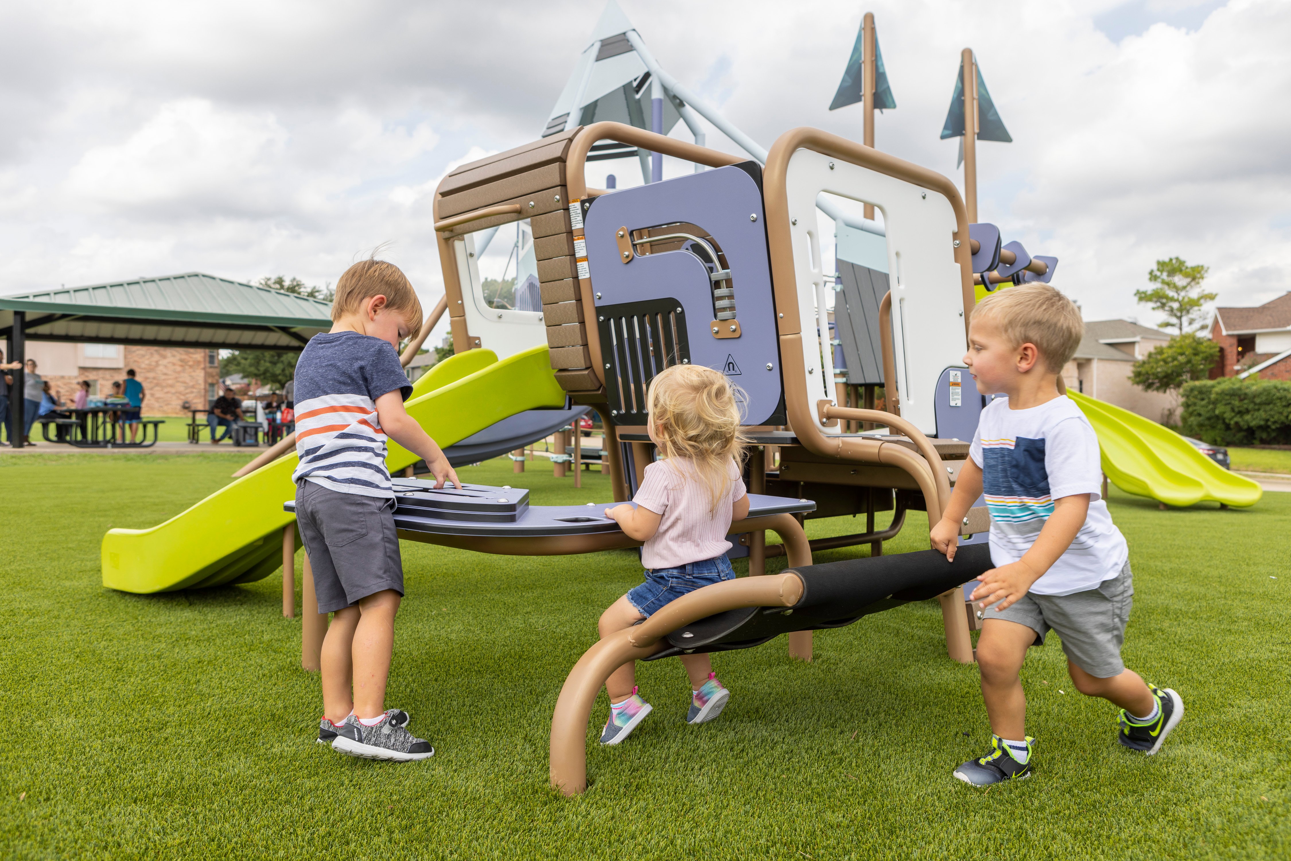 Three young children playing on the SmartPlay Cube at Daffodil Park in Lewisville, Texas